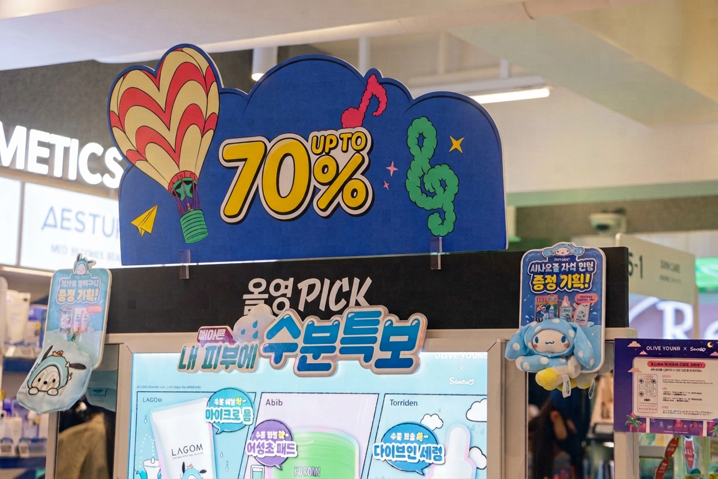 Colorful skincare promotion display reading “UP TO 70%,” with a hot-air balloon and plush toys.
