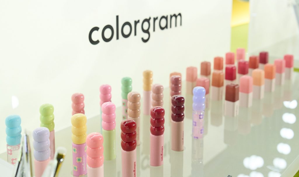 Colorful cosmetic tubes are displayed beneath a “colorgram” sign.