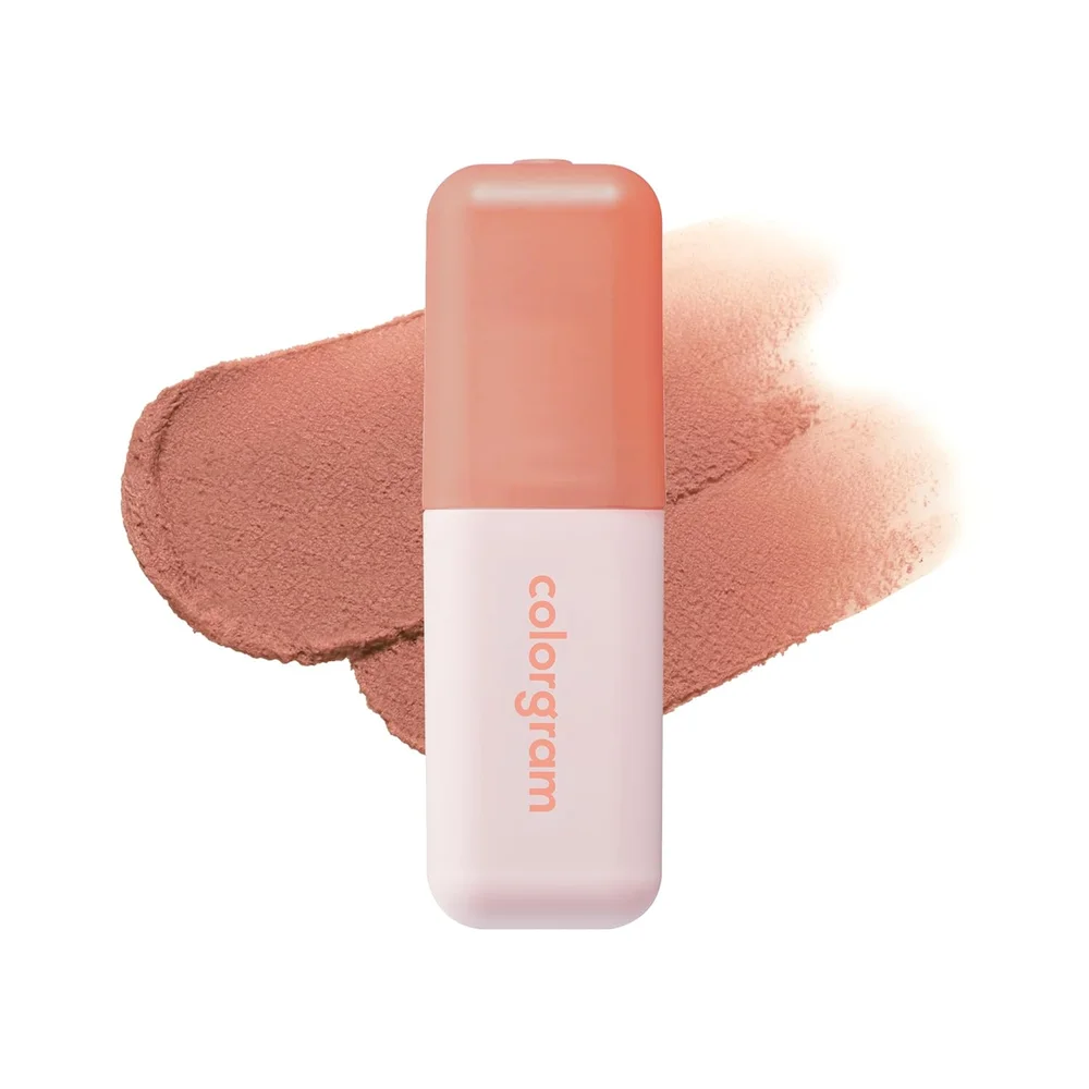 A peach-and-white cosmetic stick labeled colorgram rests over a pink makeup swatch.