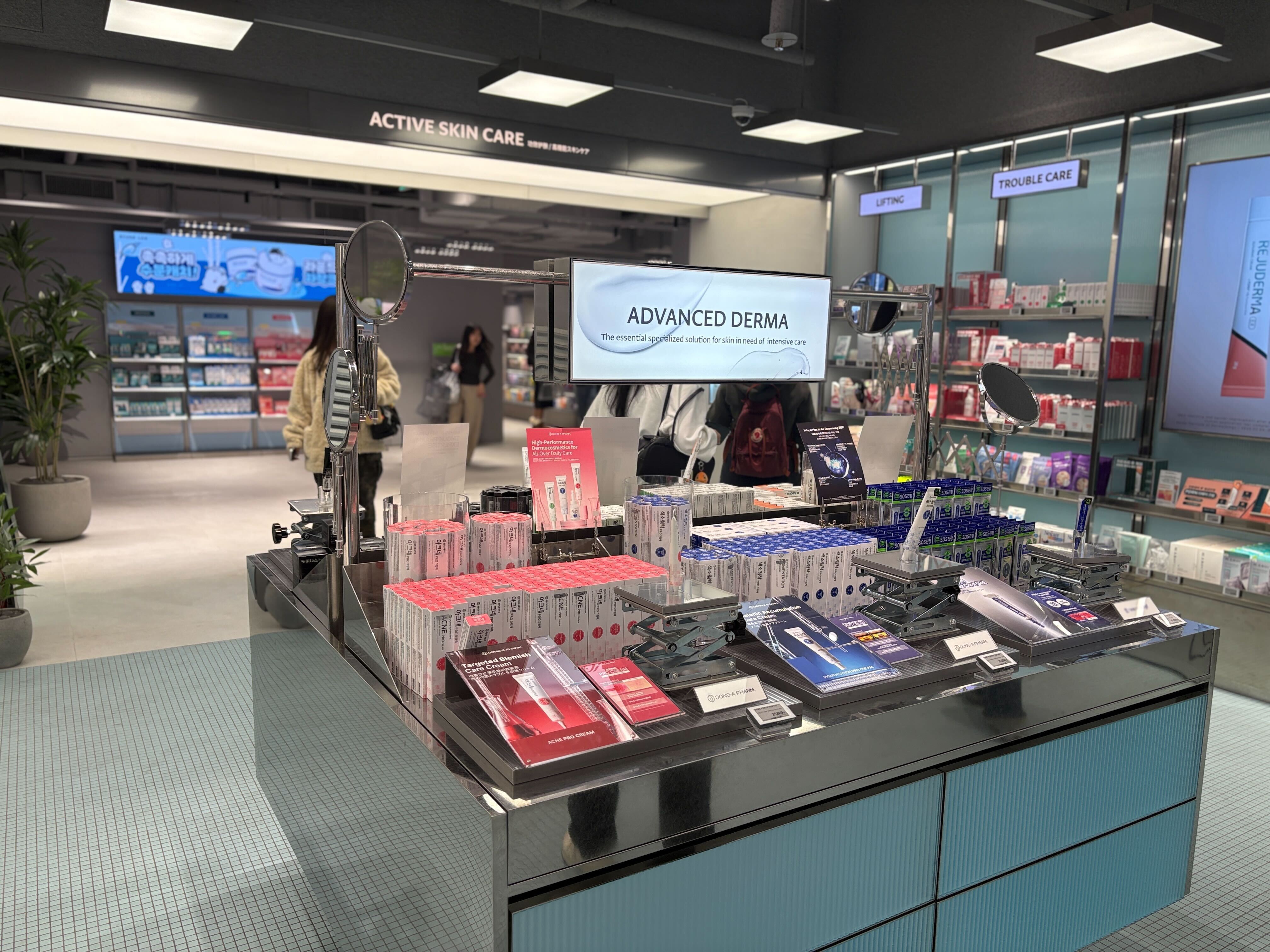 A skincare store displays beauty products beneath signs for active skin care and advanced derma.
