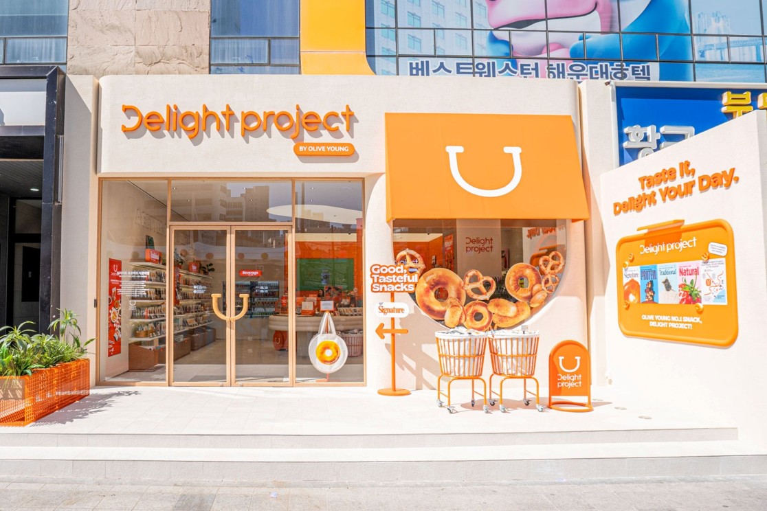 오렌지색으로 꾸민 ‘Delight project’ 매장 앞에 도넛 모형과 쇼핑 카트가 놓여 있다.