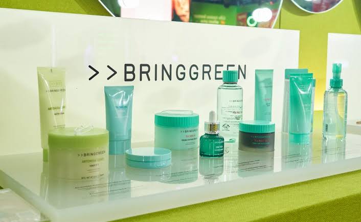 Green and turquoise skin-care products displayed beneath a sign reading “BRINGGREEN.”