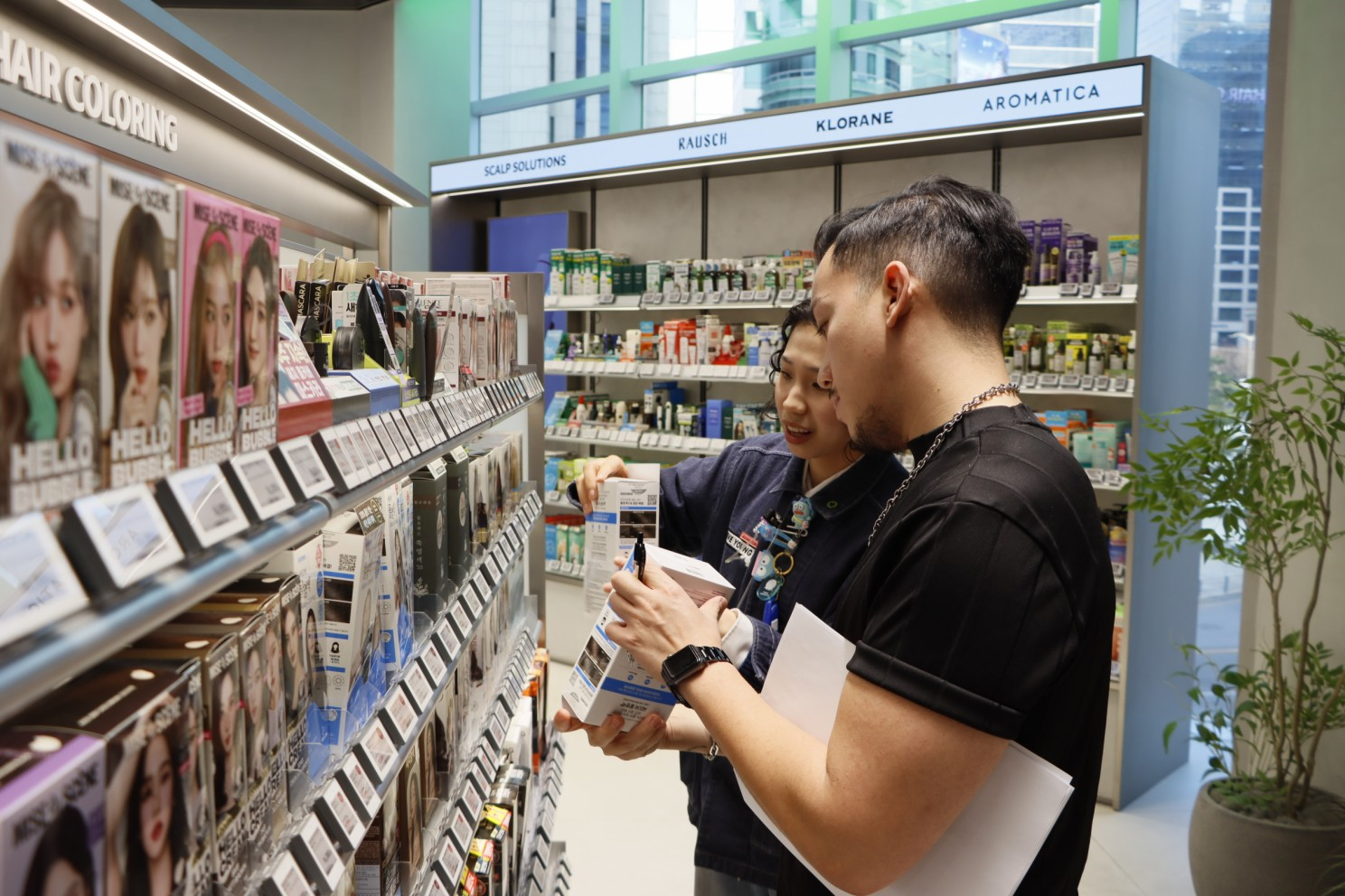 Two people examine boxed beauty products in a cosmetics store.