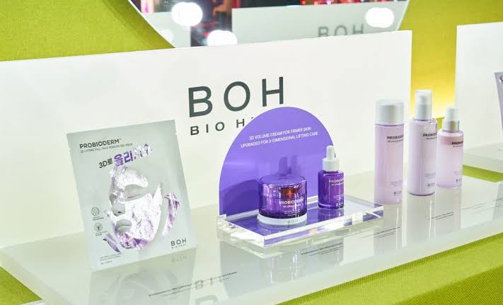 BOH skincare products and packaging are displayed on a glass shelf at a trade-show booth.