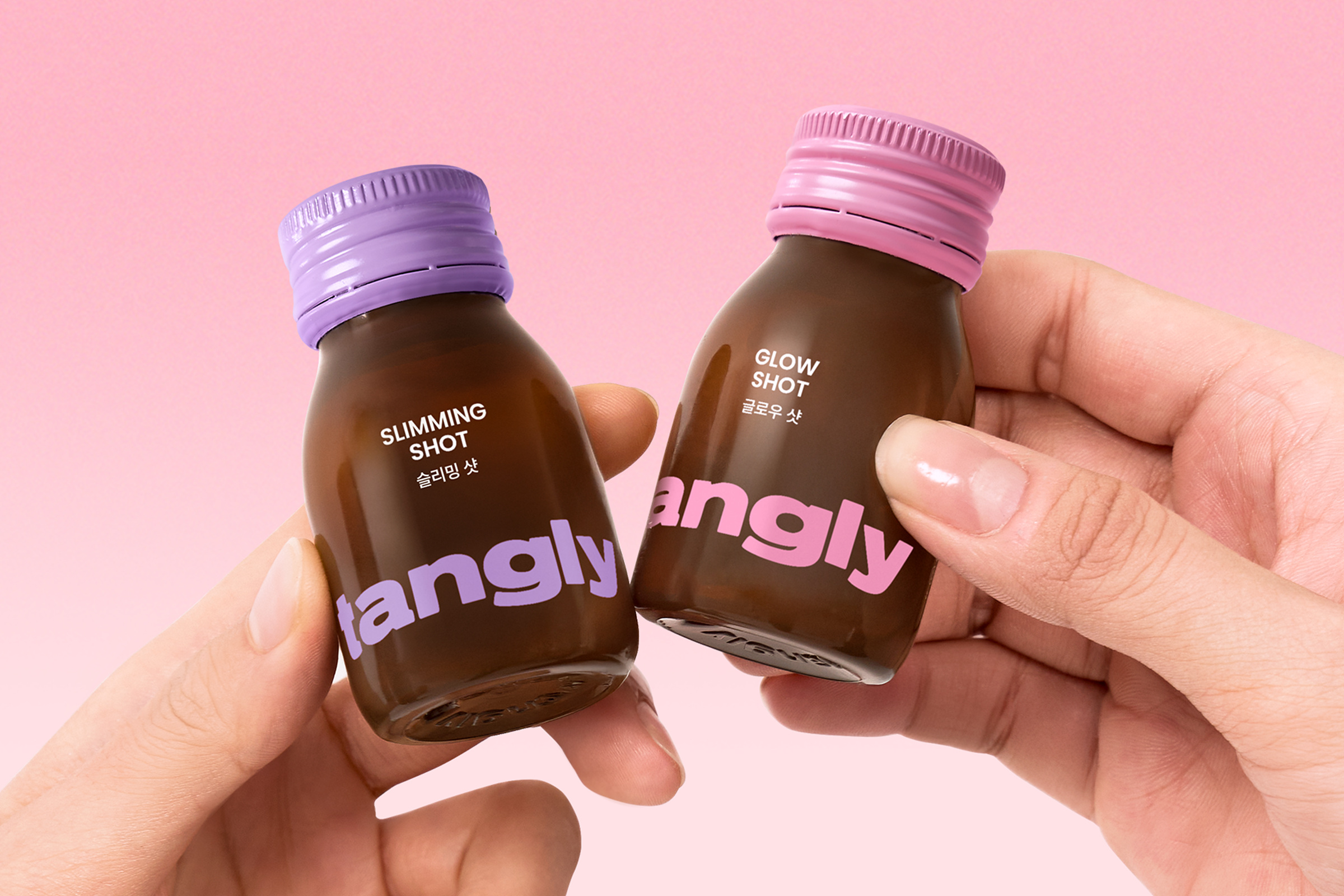 ピンクの背景で、両手が「SLIMMING SHOT」と「GLOW SHOT」と書かれた小瓶を持っている。