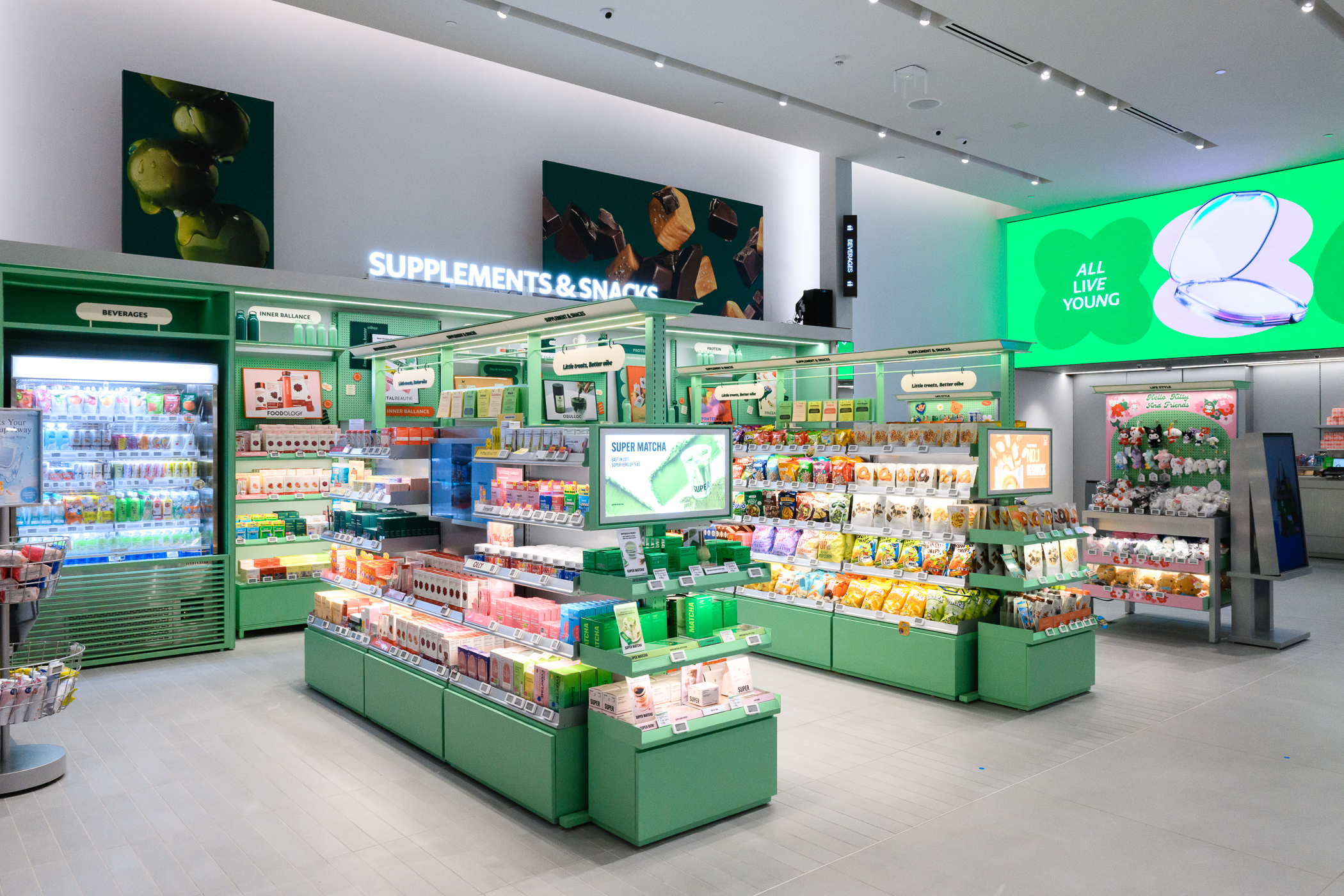 緑色の棚に飲料やサプリメント、菓子などが並ぶ明るい店内