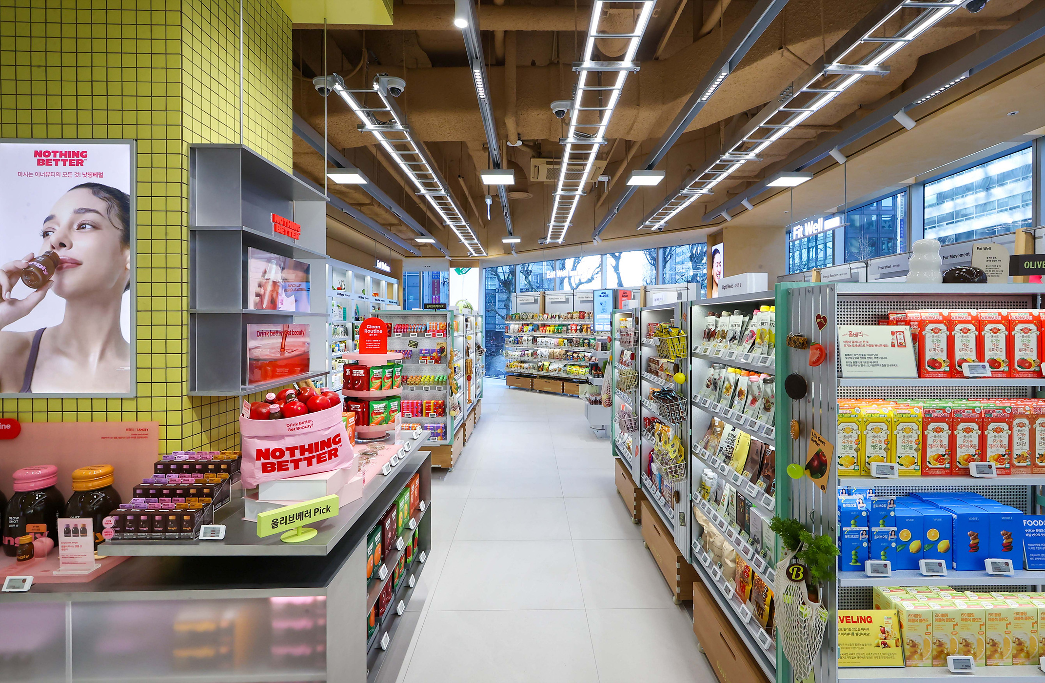 飲料や食品の商品棚が並ぶ、明るいコンビニエンスストアの店内。