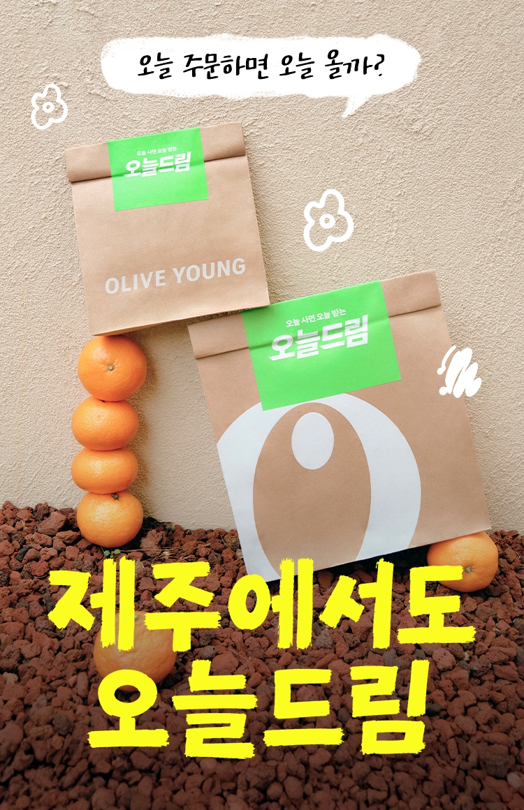 Two paper delivery bags and oranges sit on reddish stones against a textured wall.