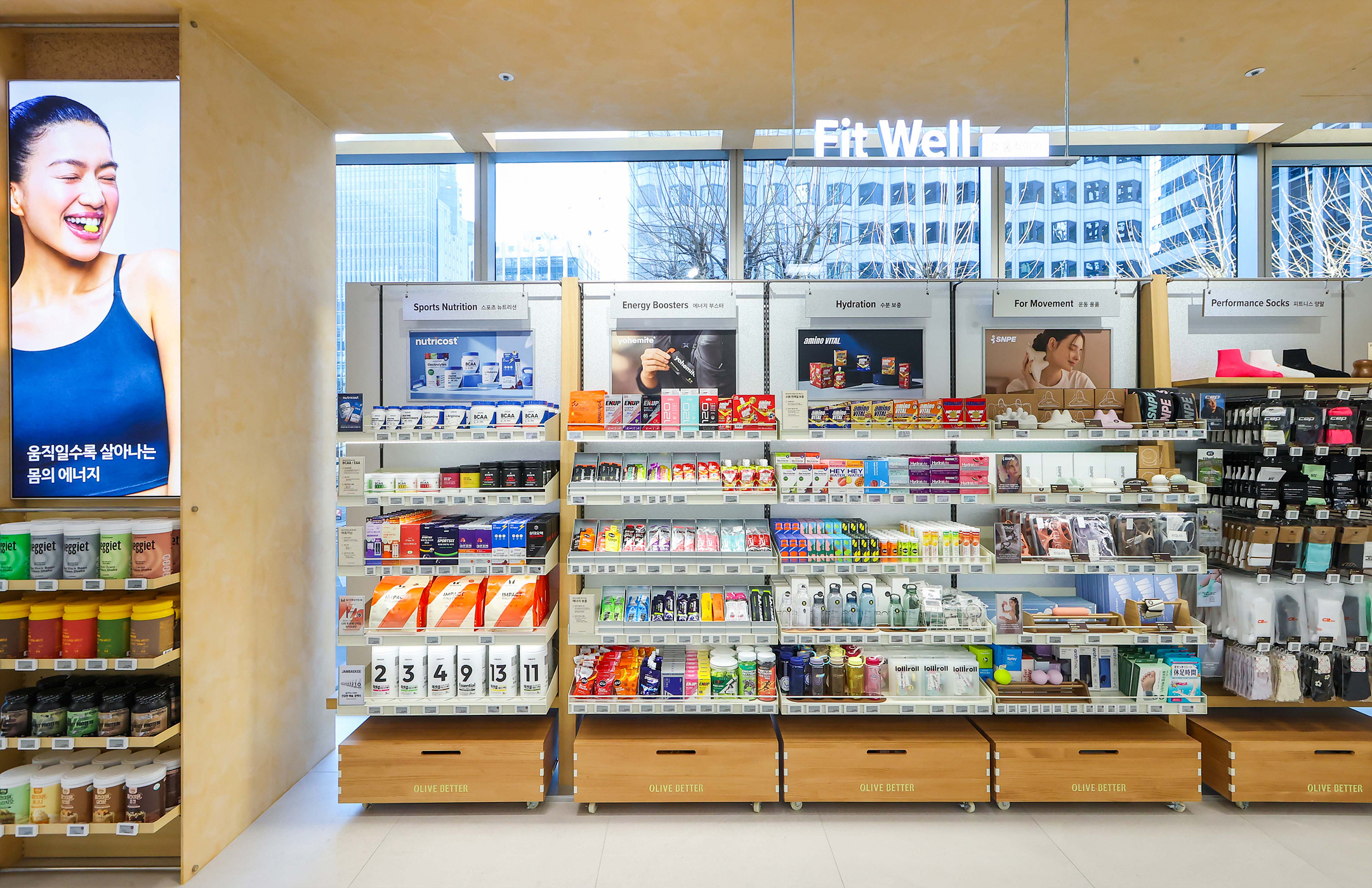 「Fit Well」の店内に、スポーツ栄養食品や飲料、ボトル、靴下などが並ぶ棚。
